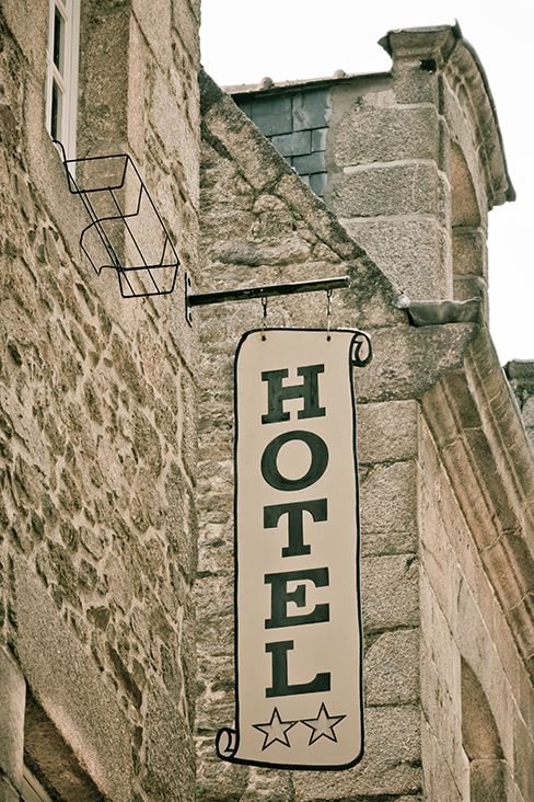 Hotel Sign on Old Stone Building in France. Toned image